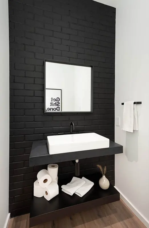 Pinewood bathroom with black brick feature wall and freestanding tub